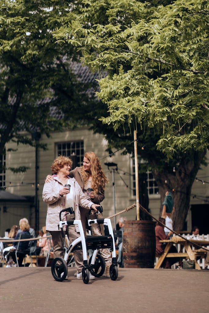 Two women in wheelchairs walking in a park